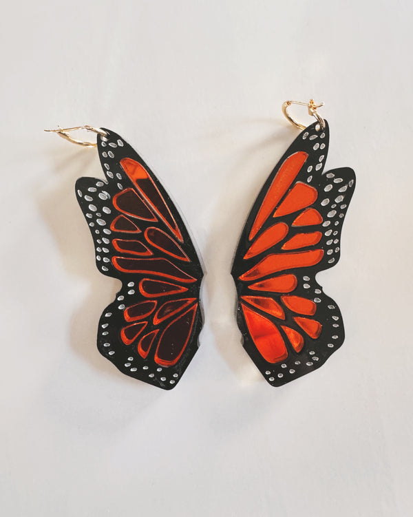 Butterfly wing earrings on a light gray background