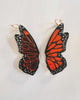 Butterfly wing earrings on a light gray background