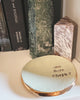 Round ceramic dish with 'one more chapter' text on a surface with books in the background